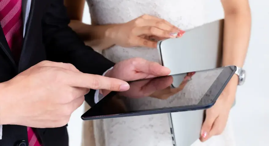 Para młoda planuje zmianę dowodu po ślubie, przeglądając dokumenty na tablecie.
