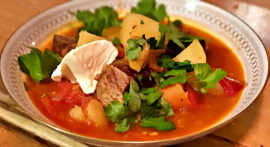 En mustig gulaschsoppa med mört kött, potatis och paprika, toppad med en klick gräddfil och färsk persilja. Perfekt vin till gulaschsoppa!