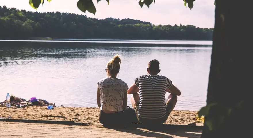 Para, siedząca na plaży, patrzy na jezioro. Czy to idealny partner dla byka?