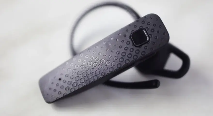 Czarna słuchawka Bluetooth z fakturą kółek, gotowa do połączenia. Dowiedz się, jak sparować słuchawki z telefonem.