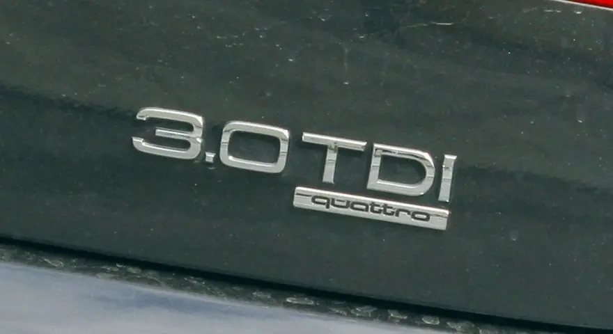 Napis "3.0 TDI quattro" na ciemnym lakierze. Ta pojemność silnika sugeruje moc i osiągi.