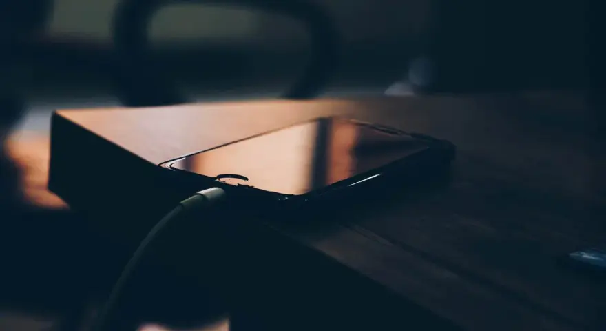 Telefon podłączony do ładowania. Szybkość ładowania telefonu zależy od wielu czynników, m.in. od mocy ładowarki i kabla.