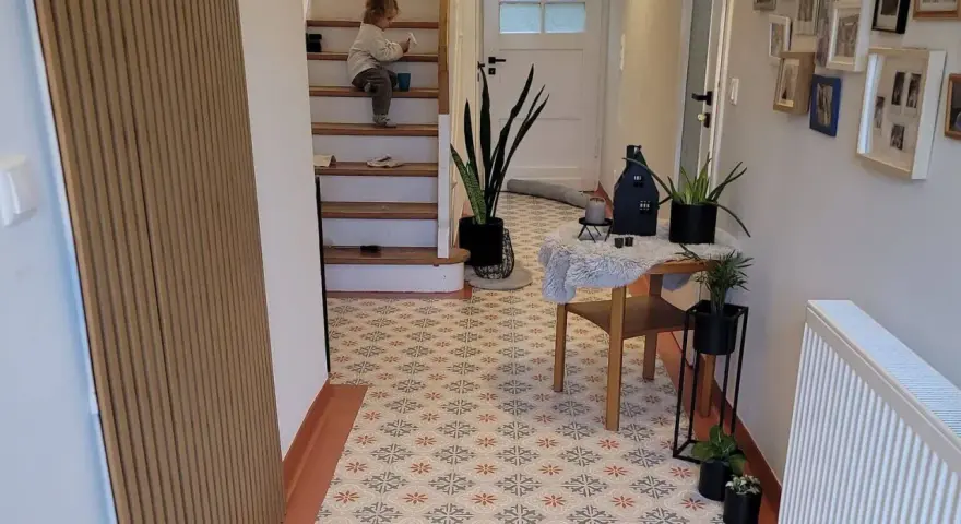 Un enfant sur les escaliers, un sol avec une peinture carrelage aux motifs floraux. La durée de vie de ce revêtement est impressionnante.