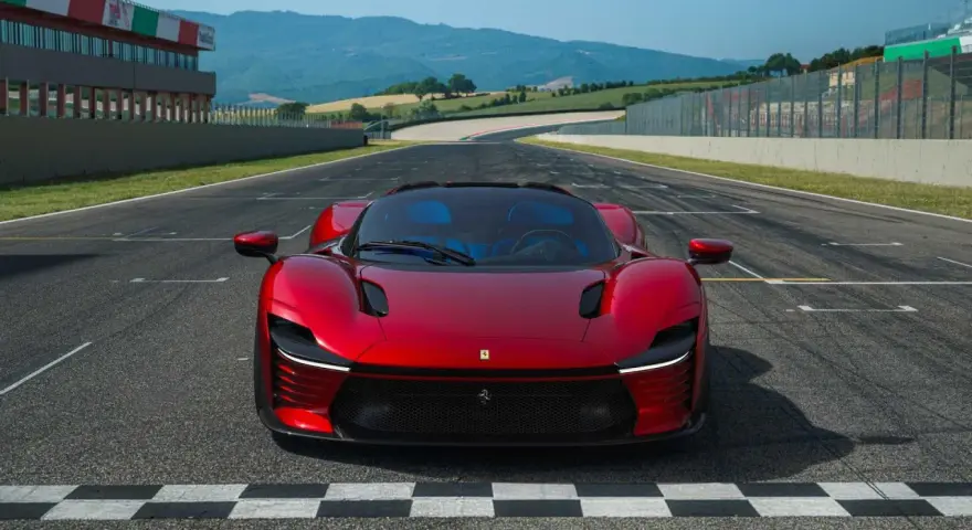 Czerwone Ferrari Daytona SP3 na linii startu toru wyścigowego, gotowe do przekroczenia mety.