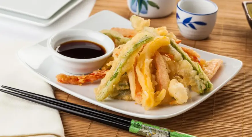 Crujiente tempura de verduras, con zanahoria, calabacín y pimiento, servida con salsa de soja.