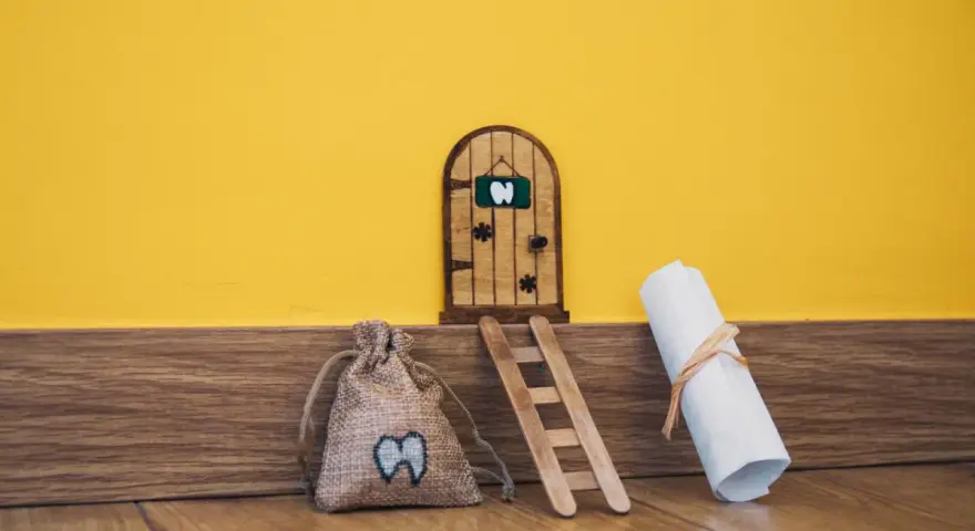 Puerta de madera para hacerla del ratoncito pérez, con una bolsa de dientes y un pergamino.