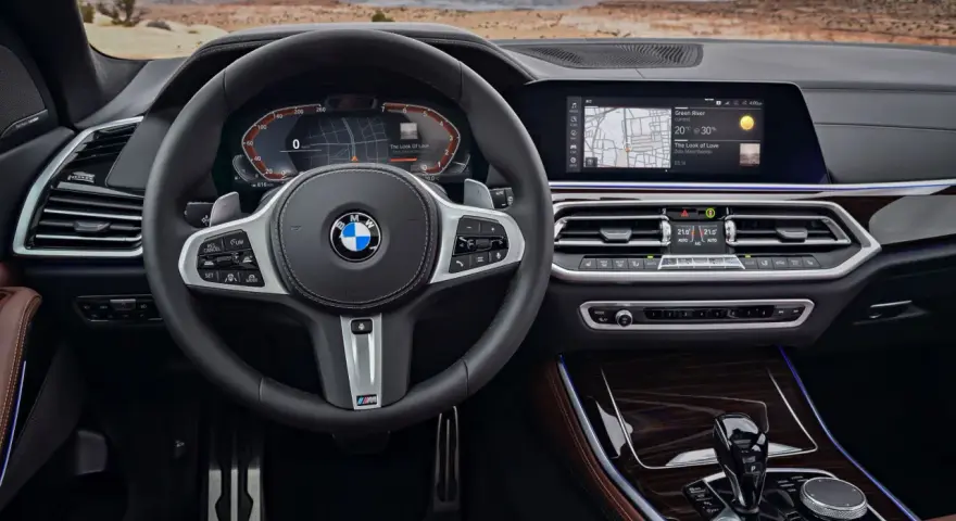 Wnętrze BMW z systemem BMW Live Cockpit Professional. Kierownica, ekran nawigacji i panel klimatyzacji.