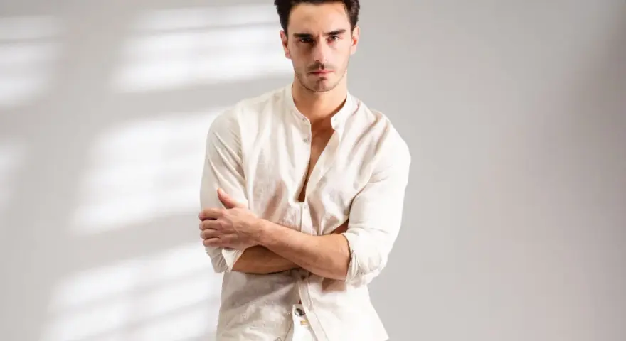 Uomo con outfit bianco e nero, camicia lino con colletto alla coreana e pantaloni chiari.