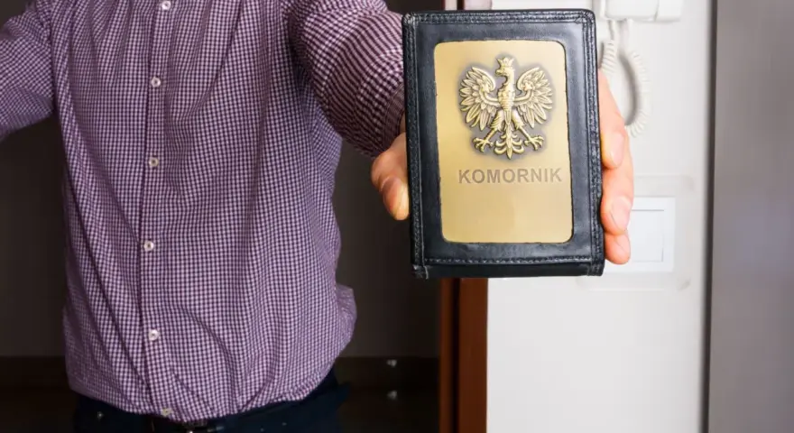 Komornik pokazuje legitymację. Zastanawiasz się, ile komornik może zabrać z pensji minimalnej?