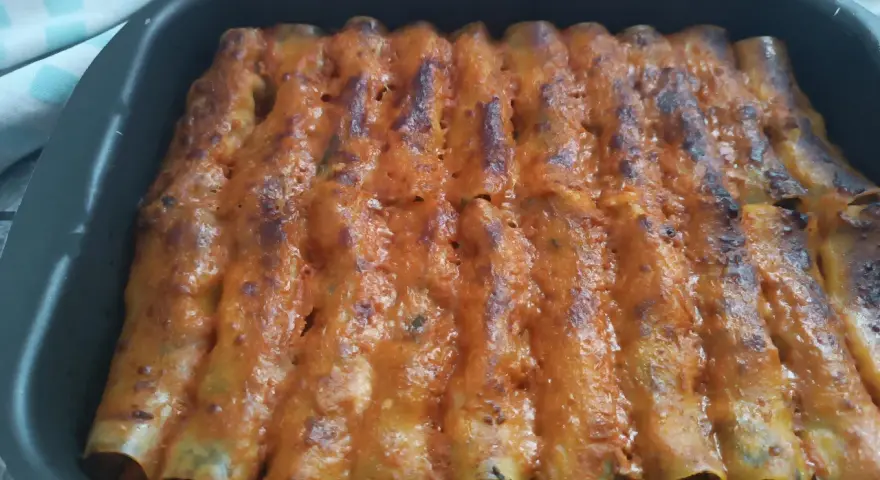 Cannelloni di carne ricetta della nonna, cotti al forno e ricoperti di sugo rosso e formaggio fuso.