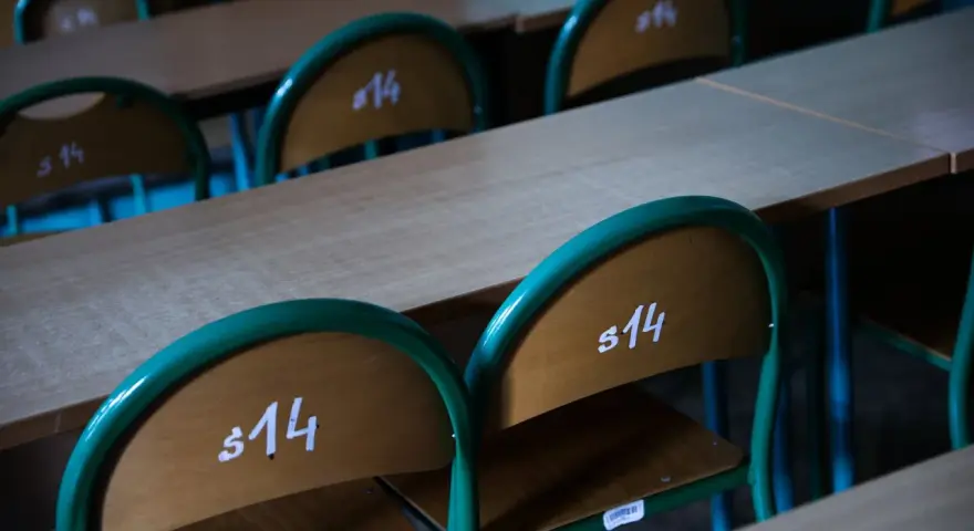 Puste ławki szkolne z numerami "s14" sugerują odwołane lekcje w szkołach 2026.