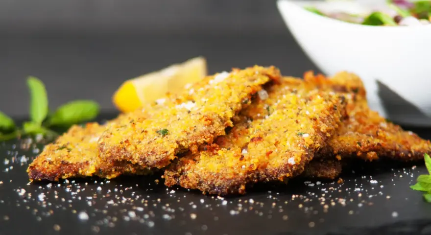 Cotoletta alla palermitana dorata e croccante, guarnita con limone e menta.