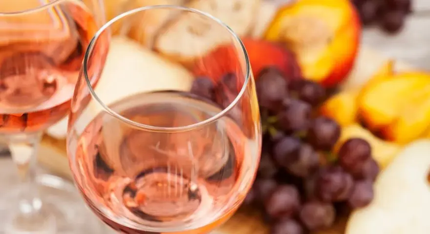 Idealny przepis na wino brzoskwiniowe: orzeźwiający różowy napój z owocami, serem i pieczywem.
