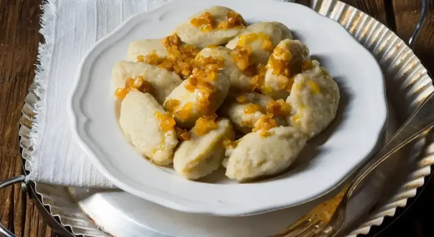 Pyszne kluski śląskie z okrasą, idealne na obiad. Warto wiedzieć, ile gotować pierogi, by były idealne.