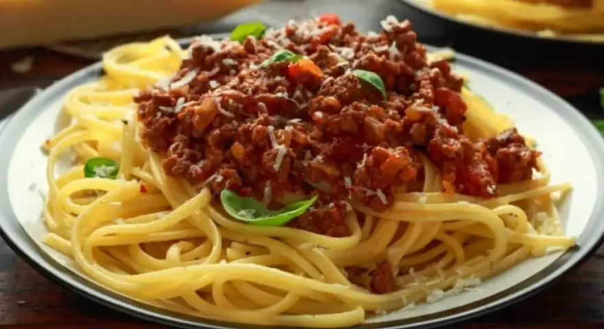 Pyszne spaghetti bolognese z mielonym mięsem, pomidorami i bazylią. Idealne przyprawy do spaghetti podkreślają smak dania.