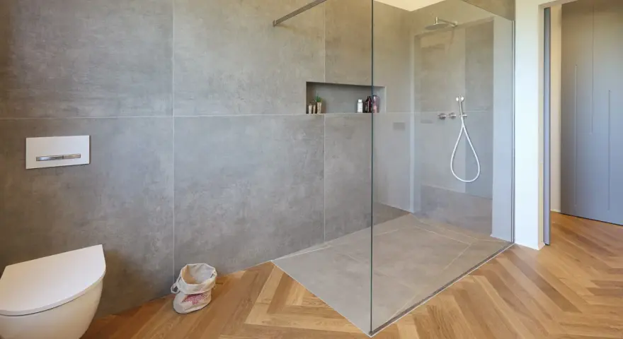 Bagno moderno con doccia walk-in, vaso sospeso e finiture in legno. Il significato di doccia walk-in è uno spazio aperto e accessibile.