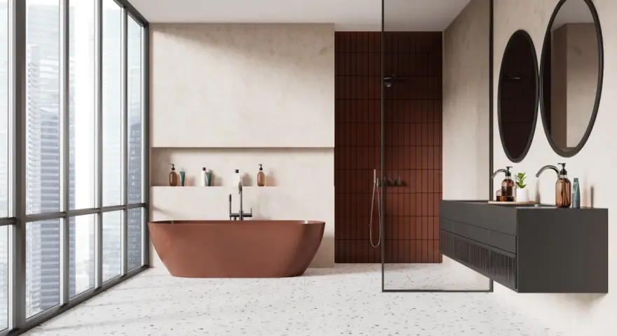 Salle de bain moderne avec baignoire rouille, douche en briques rouges et lavabo suspendu. Le sol en terrazzo offre une belle dimension carrelage.