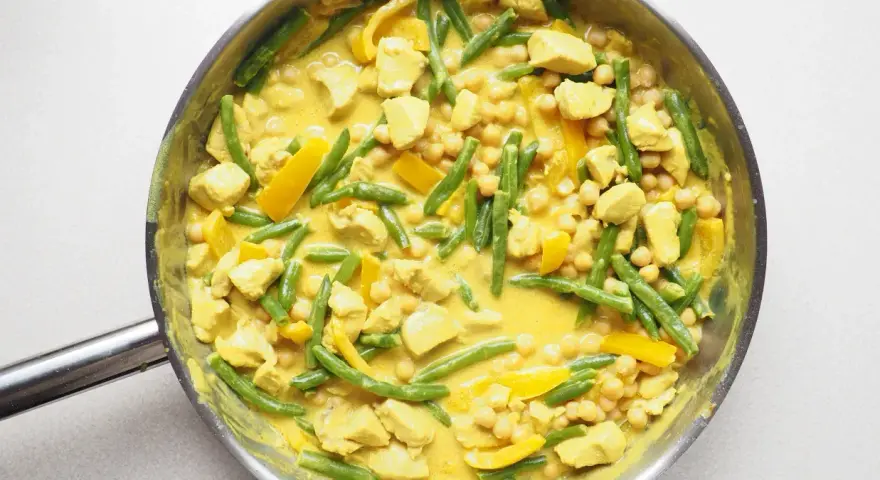 Pyszne danie curry z kurczakiem, fasolką szparagową i ciecierzycą w kremowym sosie.