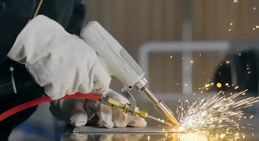 Ręce w rękawicach wykonują spawanie TIG, tworząc snop iskier na metalowej powierzchni.