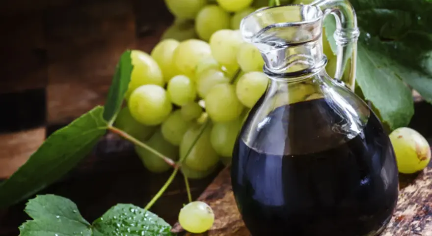 Ciemny płyn w karafce i winogrona. Szukasz, czym zastąpić ocet balsamiczny? Oto inspiracja.