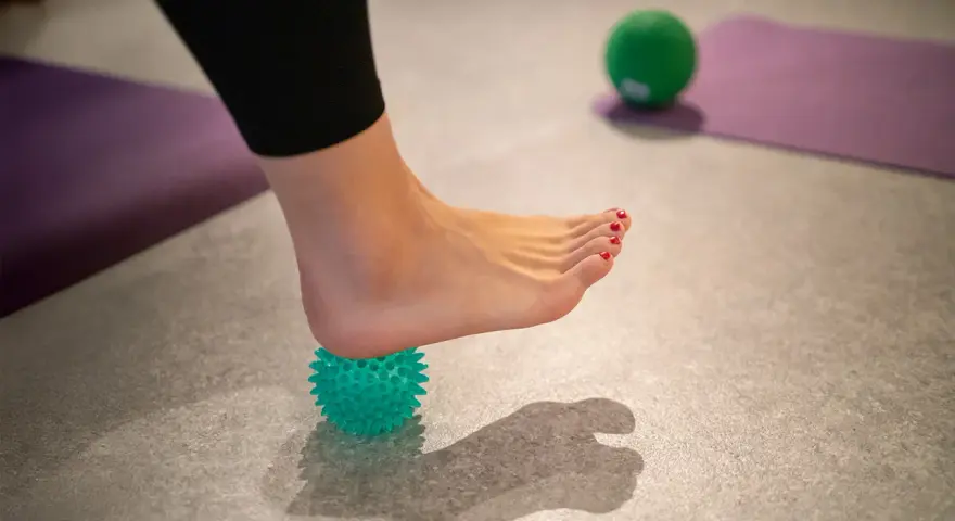 Fußmassage mit Igelball zur Linderung einer gereizten Achillessehne.