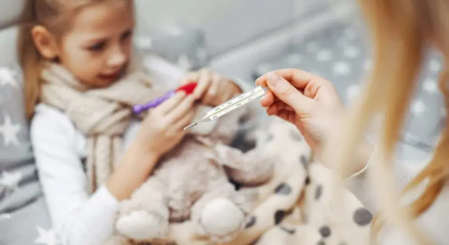 Chora dziewczynka z gorączką, mama mierzy temperaturę. Czy to rotawirus?
