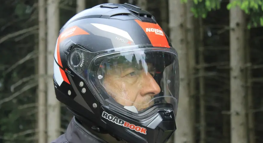 Uomo con casco Nolan, simbolo di sicurezza e avventura su due ruote. Il suo significato è protezione per ogni viaggio.