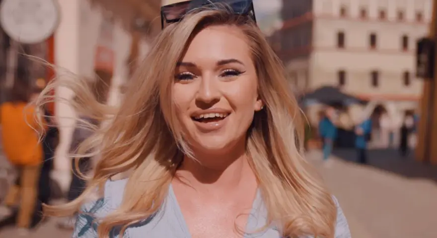 Uśmiechnięta blondynka w okularach na głowie, idealna do piosenki na 50 urodziny disco polo.