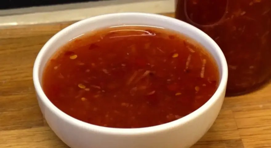 En skål med söt chili sås, redo att förhöja smaken på din favoritmat.