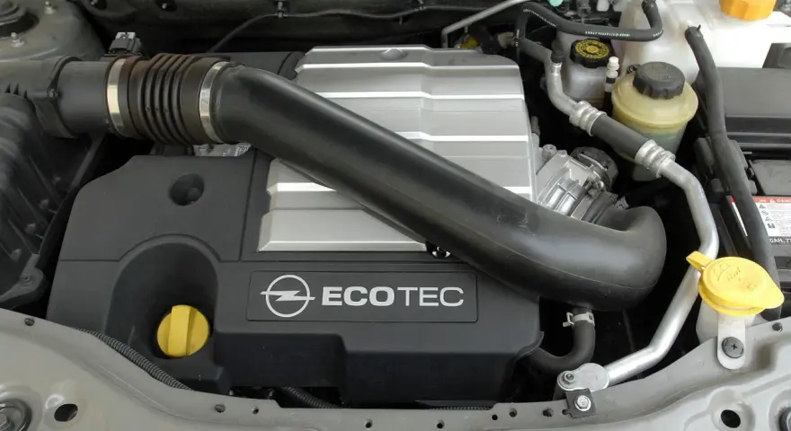 Silnik Ecotec w Oplu Antara. Widoczny jest czarny dolot powietrza, srebrna pokrywa silnika z logo Opla i napisem Ecotec.