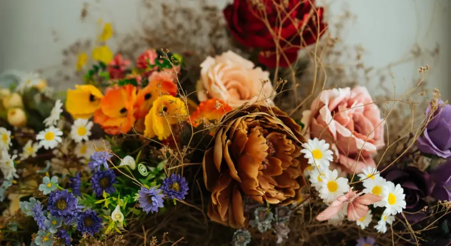 Un ramo de flores secas y artificiales, con tonos ocres, rosas, naranjas y morados. Una guía visual sobre como preservar flores para un recuerdo eterno.