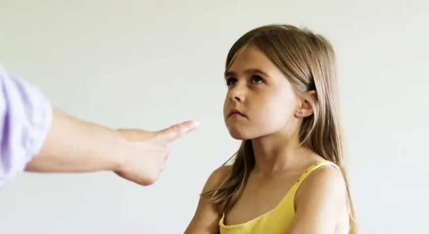 Zmarszczona buzia dziewczynki, gdy dorosły wskazuje palcem. Czasem potrzebny psycholog dla 3 latka, by zrozumieć emocje.