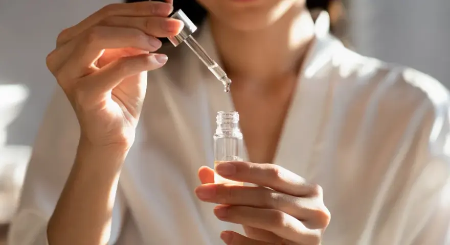 Kobieta aplikuje serum z kwasem fitynowym, dbając o swoją cerę.