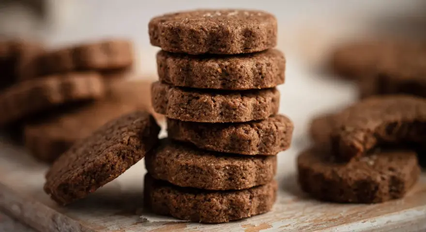 Stack of chocolate biscotti on a wooden board.