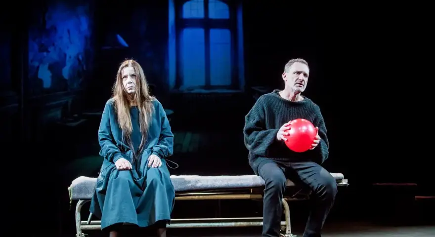 Agata Kulesza w teatrze, siedzi obok mężczyzny z czerwoną piłką.