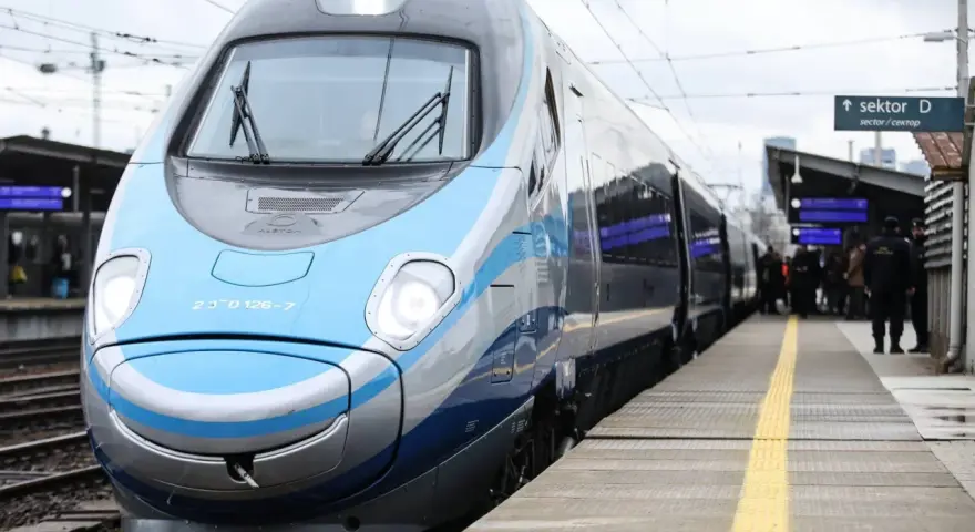 Nowoczesny, niebiesko-szary pociąg Pendolino stoi na peronie.