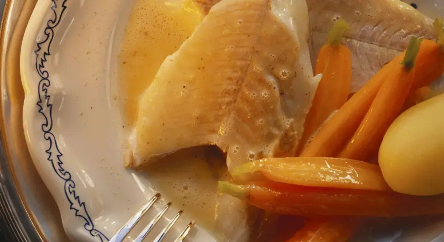 Zart gebratener Hecht mit Karotten und Kartoffeln, serviert in einer cremigen Sauce. Ein köstliches Gericht, das zeigt, wie man Hecht zubereiten kann.