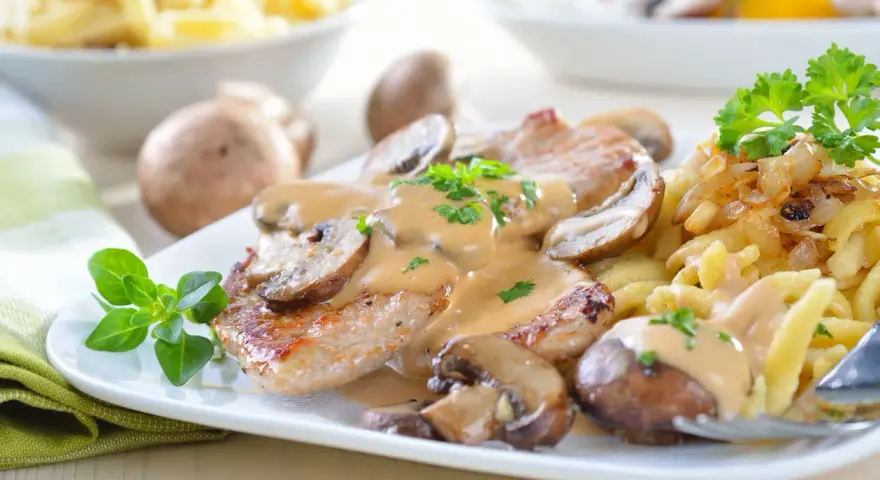 Pyszne eskalopki wieprzowe w sosie grzybowym z kluseczkami i podsmażoną cebulką.