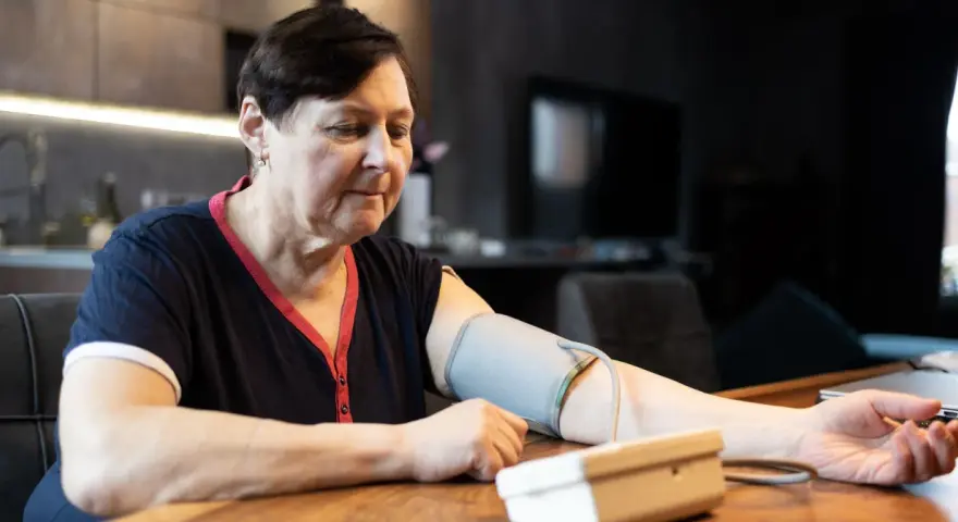 Kobieta mierzy ciśnienie. Zastanawia się, jakie ciśnienie jest niebezpieczne dla jej zdrowia.