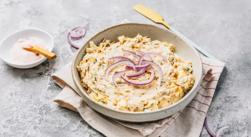 Pyszna pasta z tuńczyka i jajka, udekorowana krążkami czerwonej cebuli. Idealna na kanapki lub jako dodatek.
