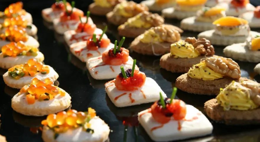 Varietà di finger food da fare in anticipo: tartine con salmone, gamberetti, uova di pesce e noci. Perfetti per ogni occasione.