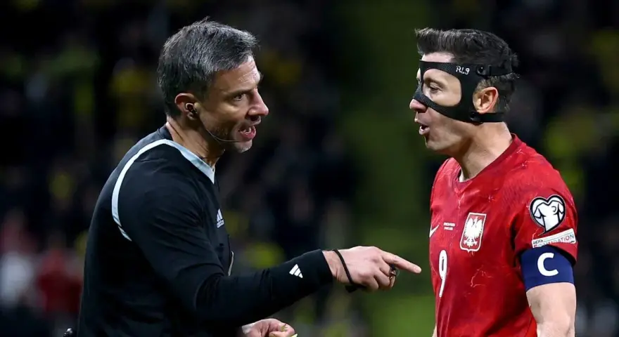Sędzia pokazuje żółtą kartkę Robertowi Lewandowskiemu, jednej z legend piłki nożnej.