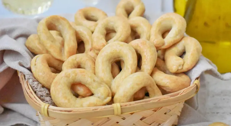 Koszyk pełen chrupiących taralli, idealnych do chrupania. Ten przepis na taralli to sekret włoskiej przekąski.