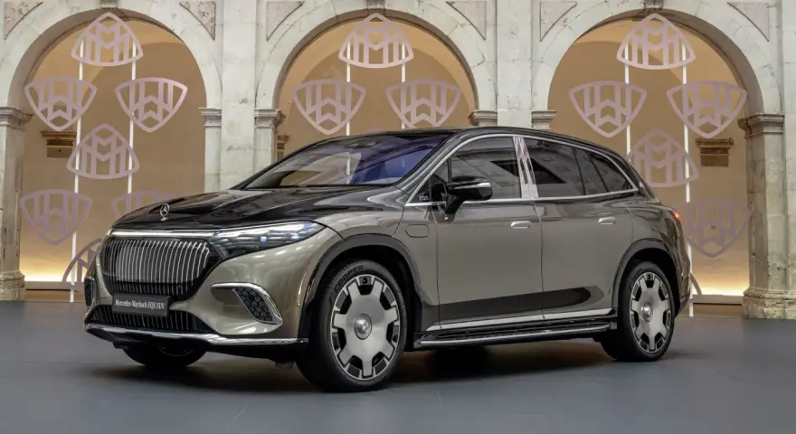 Elegancki Mercedes-Maybach EQS SUV w kolorze szaro-czarnym prezentuje się luksusowo na tle ozdobnych arkad z logo Maybach.