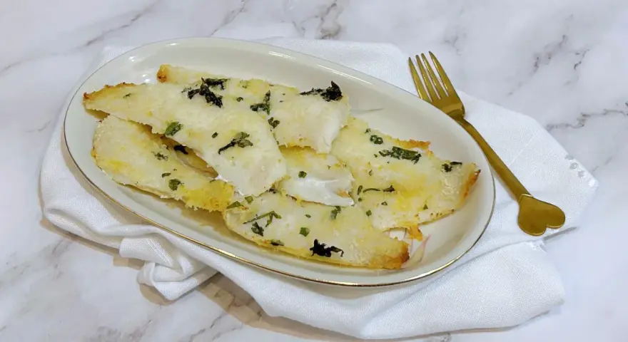 Delizioso merluzzo in friggitrice ad aria, croccante fuori e tenero dentro, guarnito con erbe aromatiche.