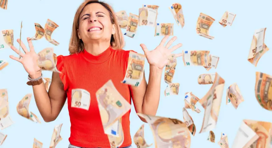 Kobieta z zamkniętymi oczami i wyciągniętymi rękami, otoczona spadającymi banknotami 50 euro. Jej wyraz twarzy sugeruje walkę z uzależnieniem od pieniędzy.