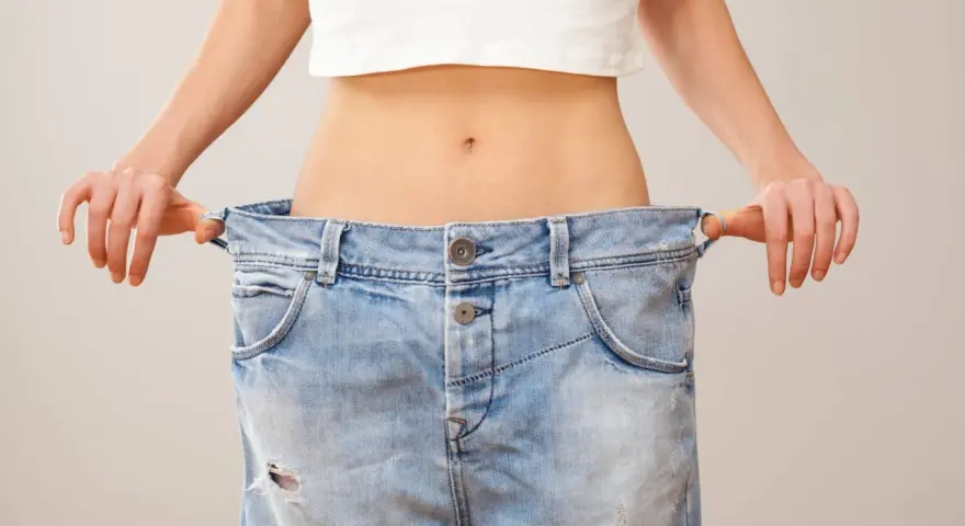 En person visar hur snabbt man kan gå ner i vikt genom att hålla upp ett par alldeles för stora jeans.