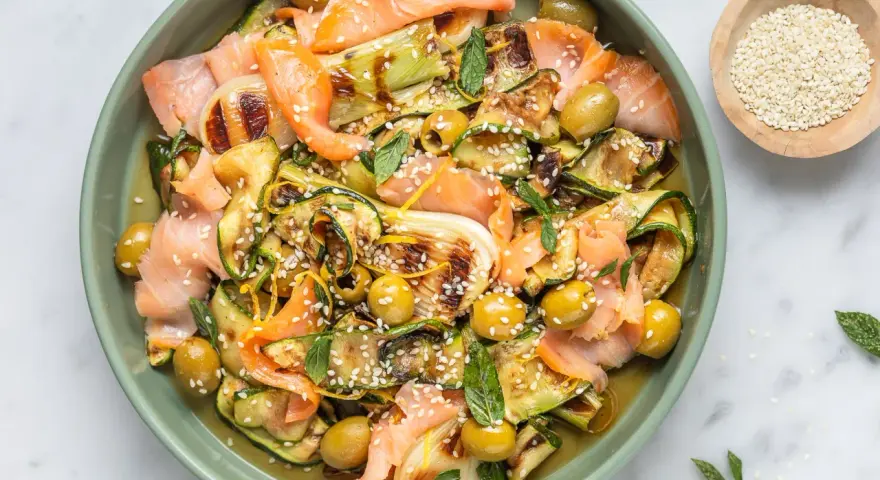 Insalata colorata con salmone affumicato, zucchine grigliate, olive e semi di sesamo. Un'idea per piatti freddi veloci e gustosi.