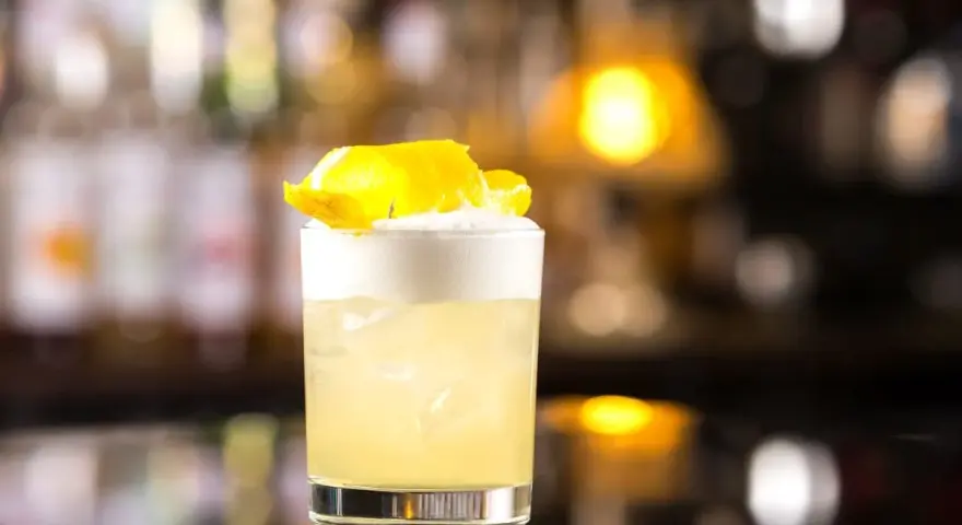 Klasyczny whisky sour przepis: orzeźwiający koktajl z pianką i skórką cytryny, idealny na każdą okazję.