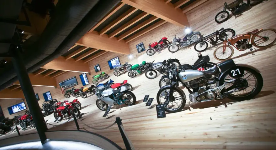 Collezione di moto d'epoca in un museo, con modelli da corsa e stradali. Un viaggio nella storia del motociclismo al museo moto passo rombo.